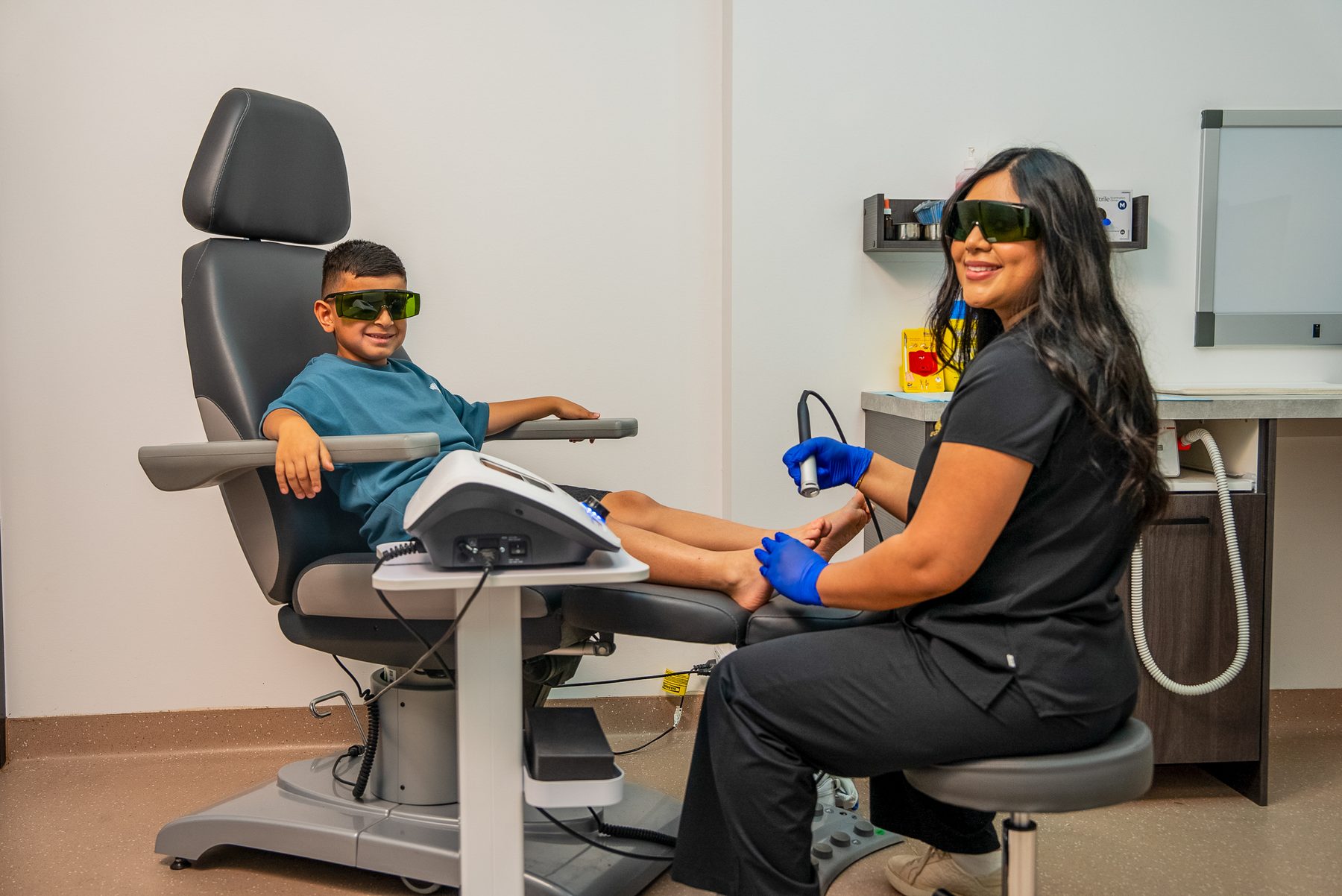 Bexley Podiatry clinician performing laser therapy on a younger patient