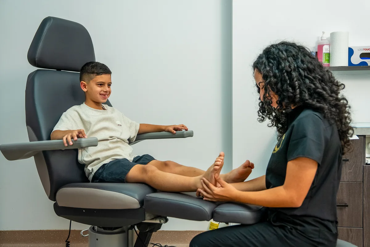 A Bexley Podiatry podiatrist checking a young child's foot in the clinic