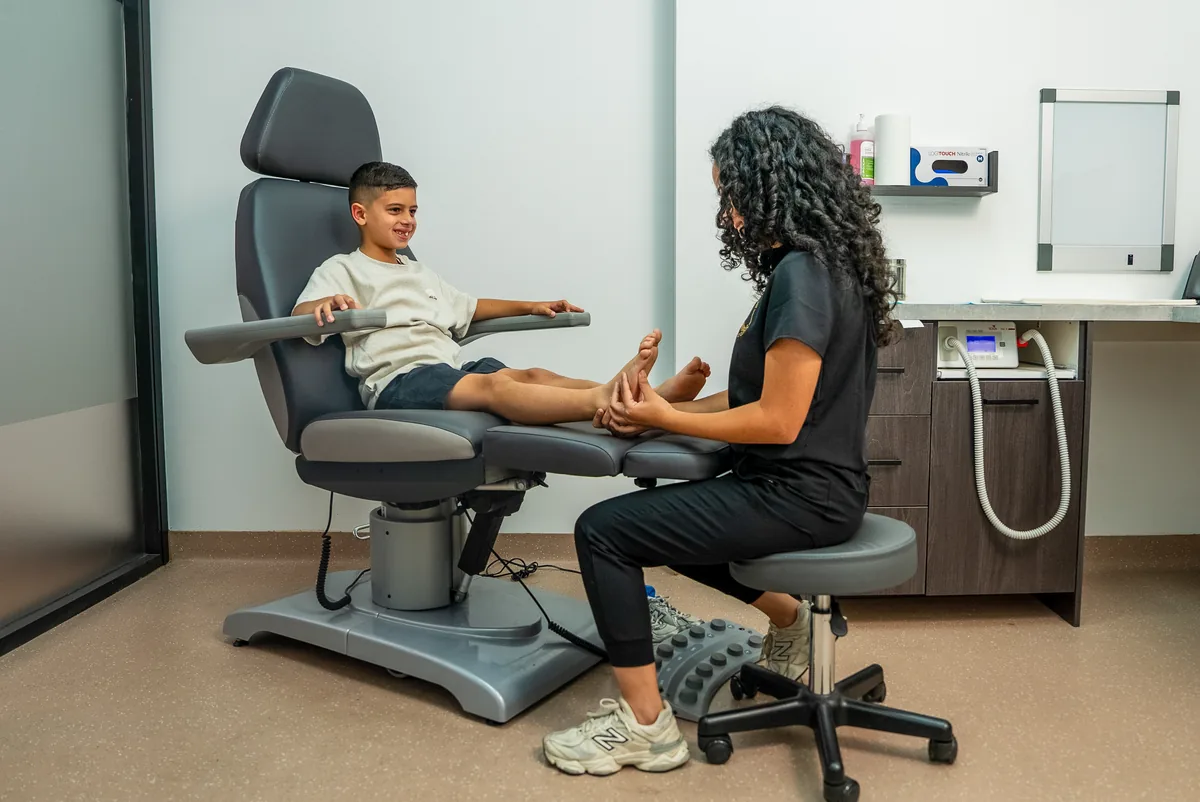 A podiatrist assessing a child's foot while a parent is present