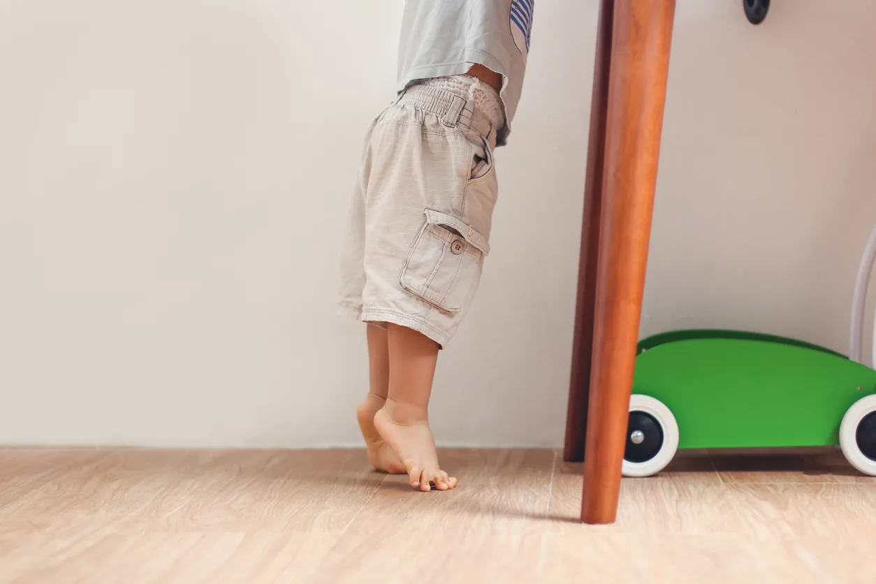A young child's bare feet as they take steps, showing developing arches