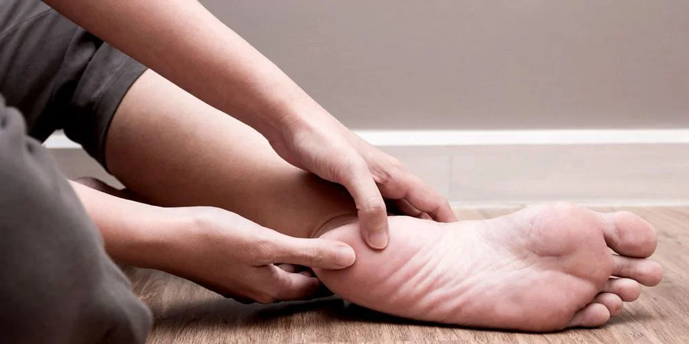 A podiatrist examining a patient's foot to locate the source of their foot pain