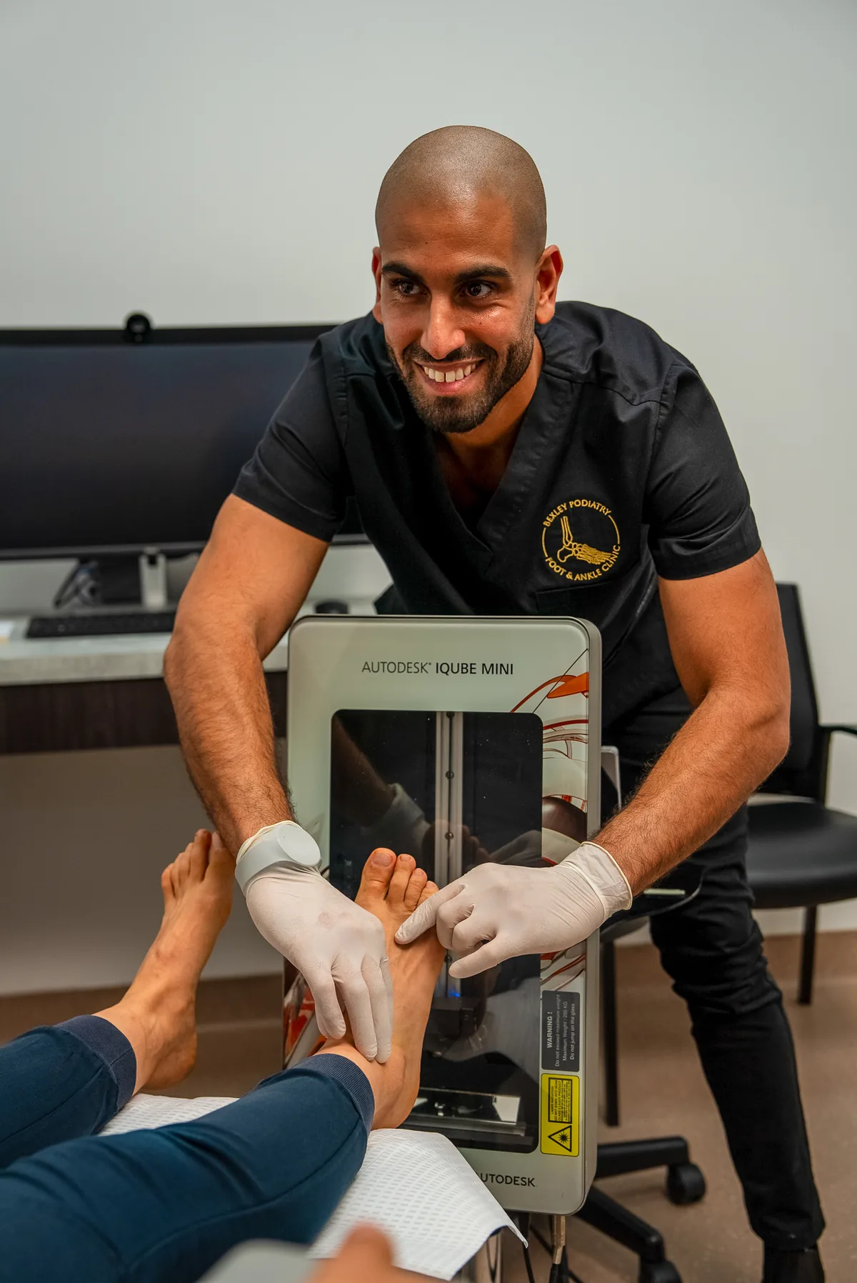 A podiatrist assessing an active patient's foot at the Bexley clinic