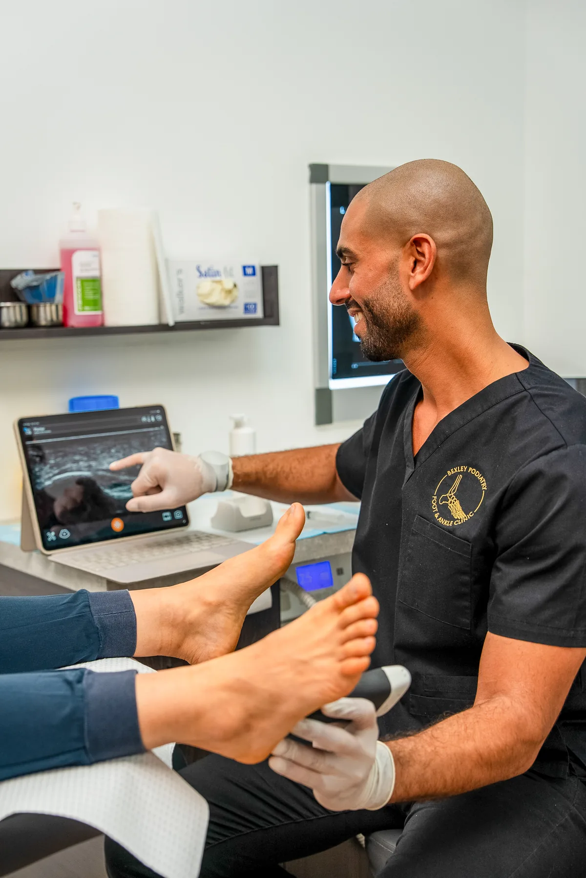 A podiatrist treating an active patient's foot at the Bexley Podiatry clinic