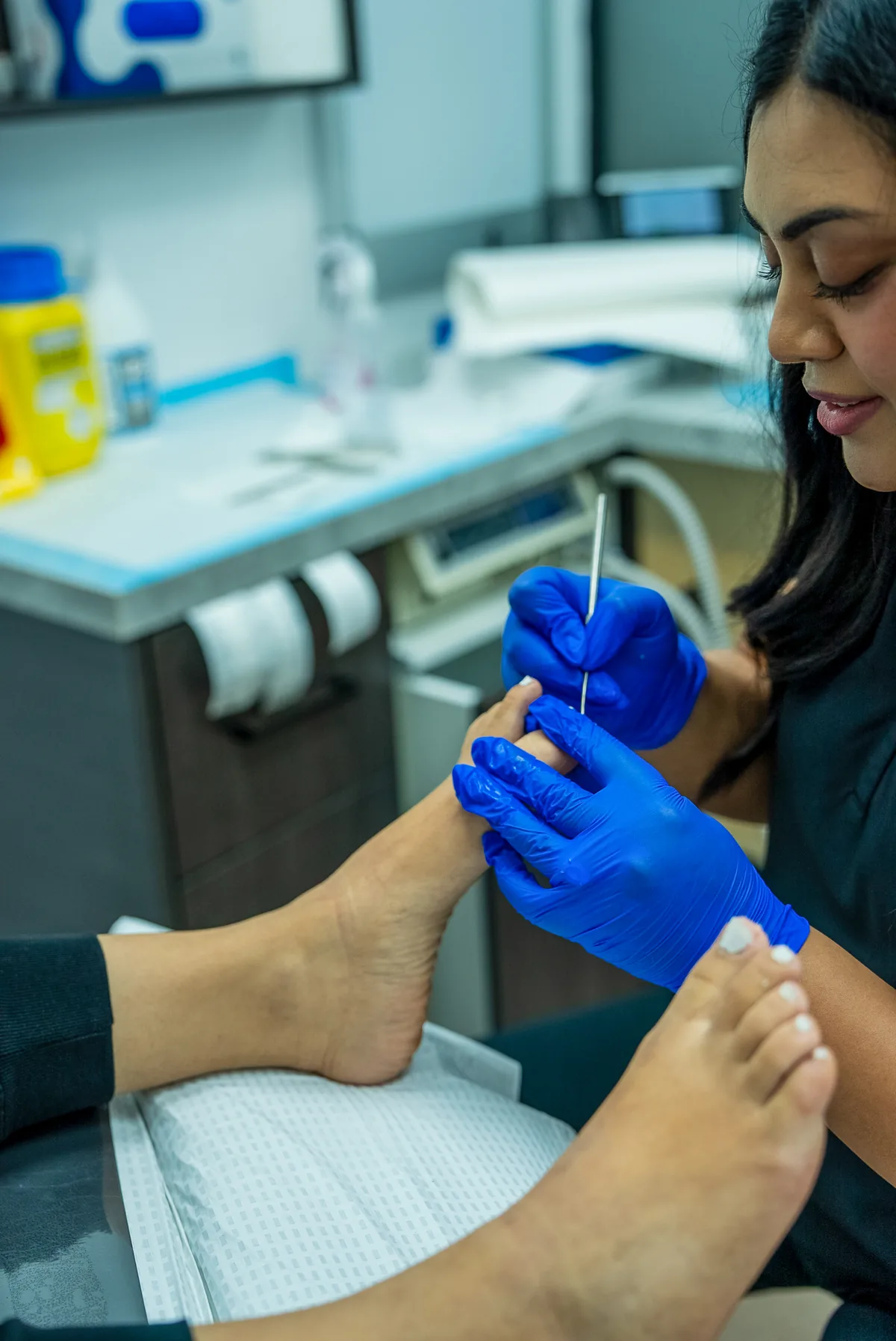 A gloved podiatrist administering local anaesthetic to a toe before a nail procedure